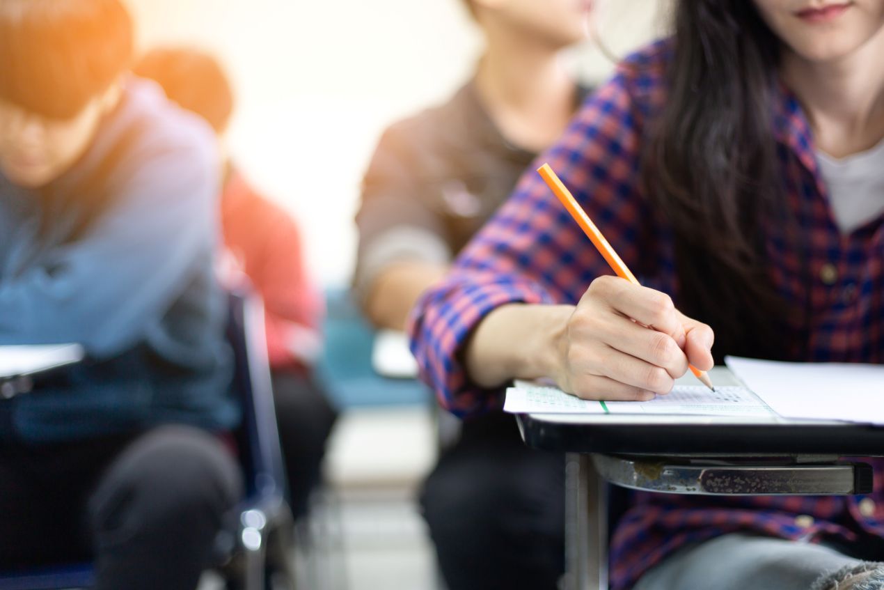 Schüler in einem Klassenzimmer während einer schriftlichen Prüfung – typischer Lernalltag an einer internationalen Privatschule Berlin