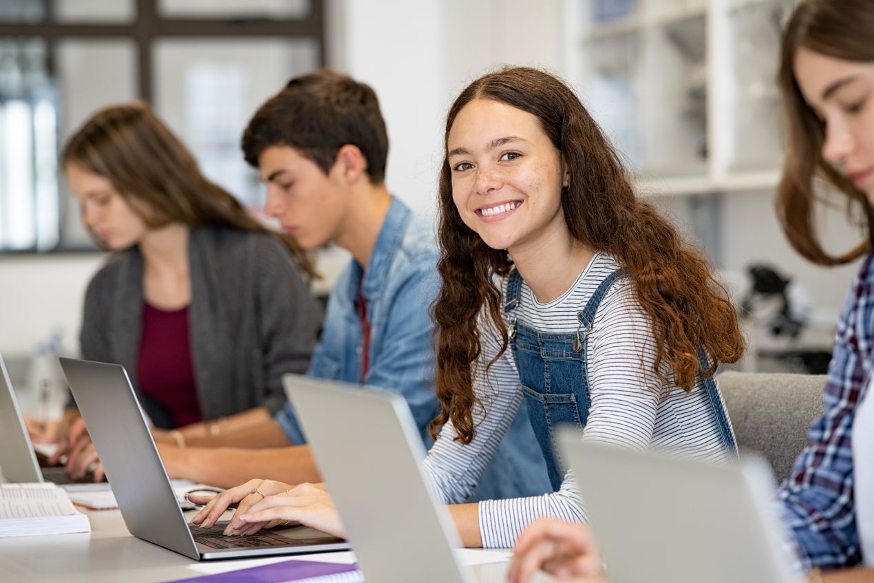 Jugendliche lernen mit Laptops in einem modernen Klassenraum – digitales Lernen an einer internationalen Privatschule Berlin