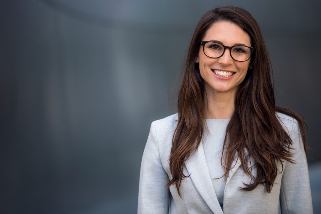 Lächelnde Frau mit langen Haaren im Business-Outfit | Hair Extensions